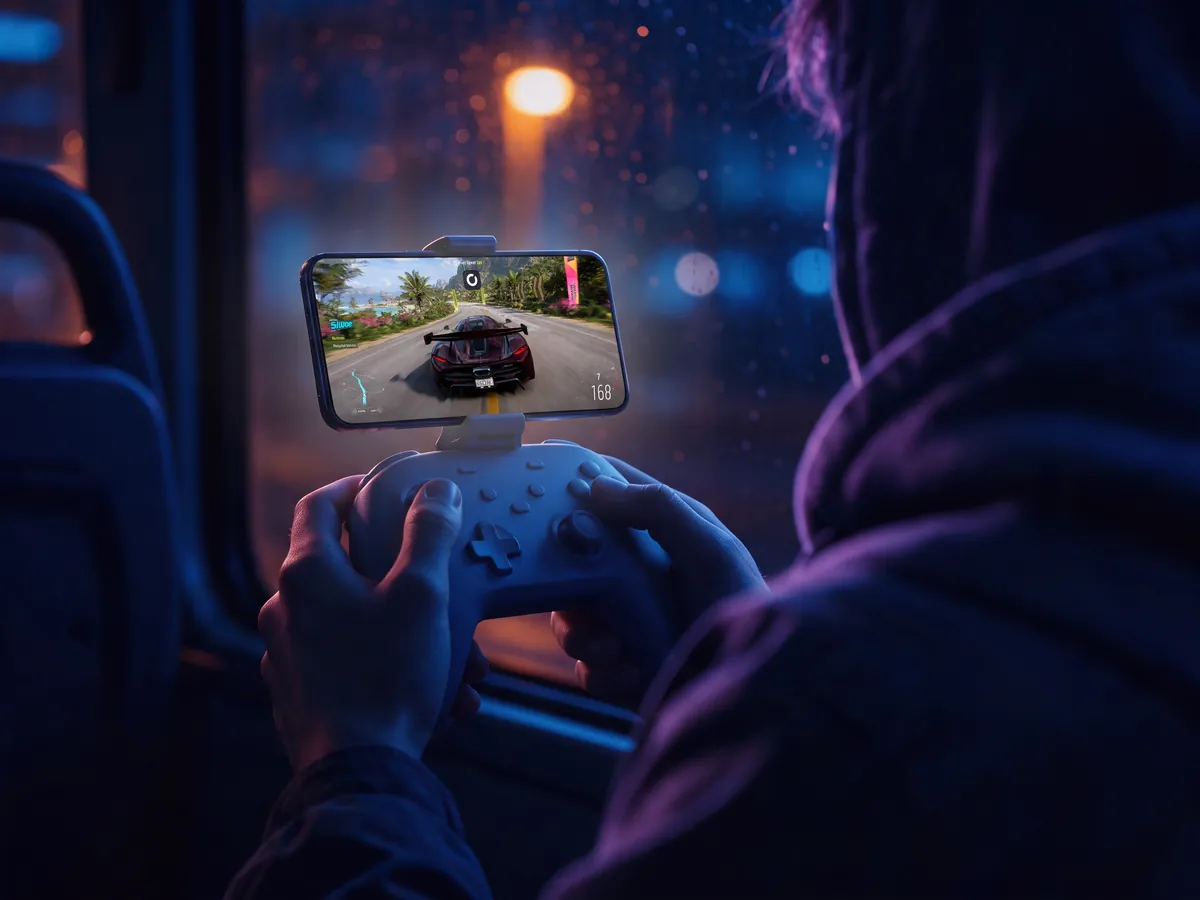 Forza Horizon 5 on an iPhone clipped on a controller on a night bus