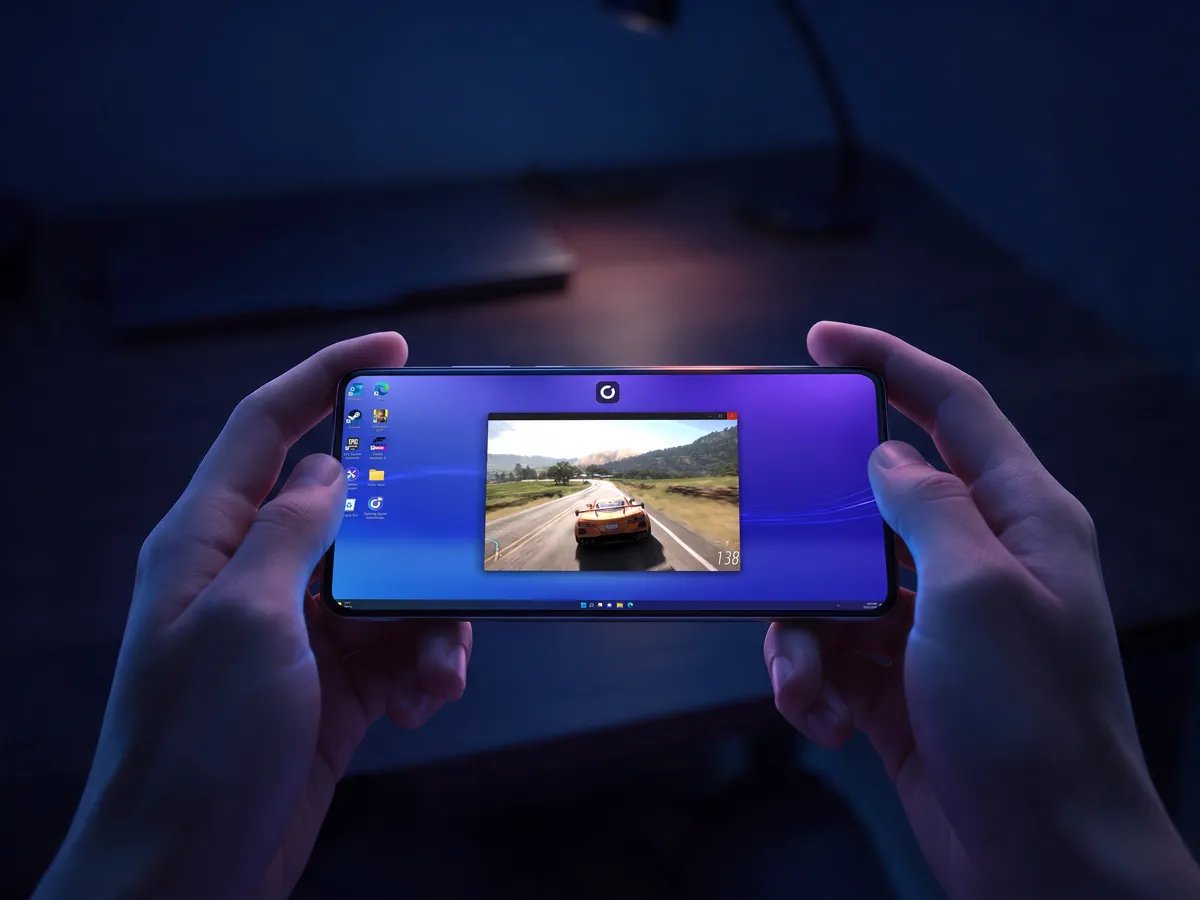 A Windows desktop with a game window on an iPhone held in both hands